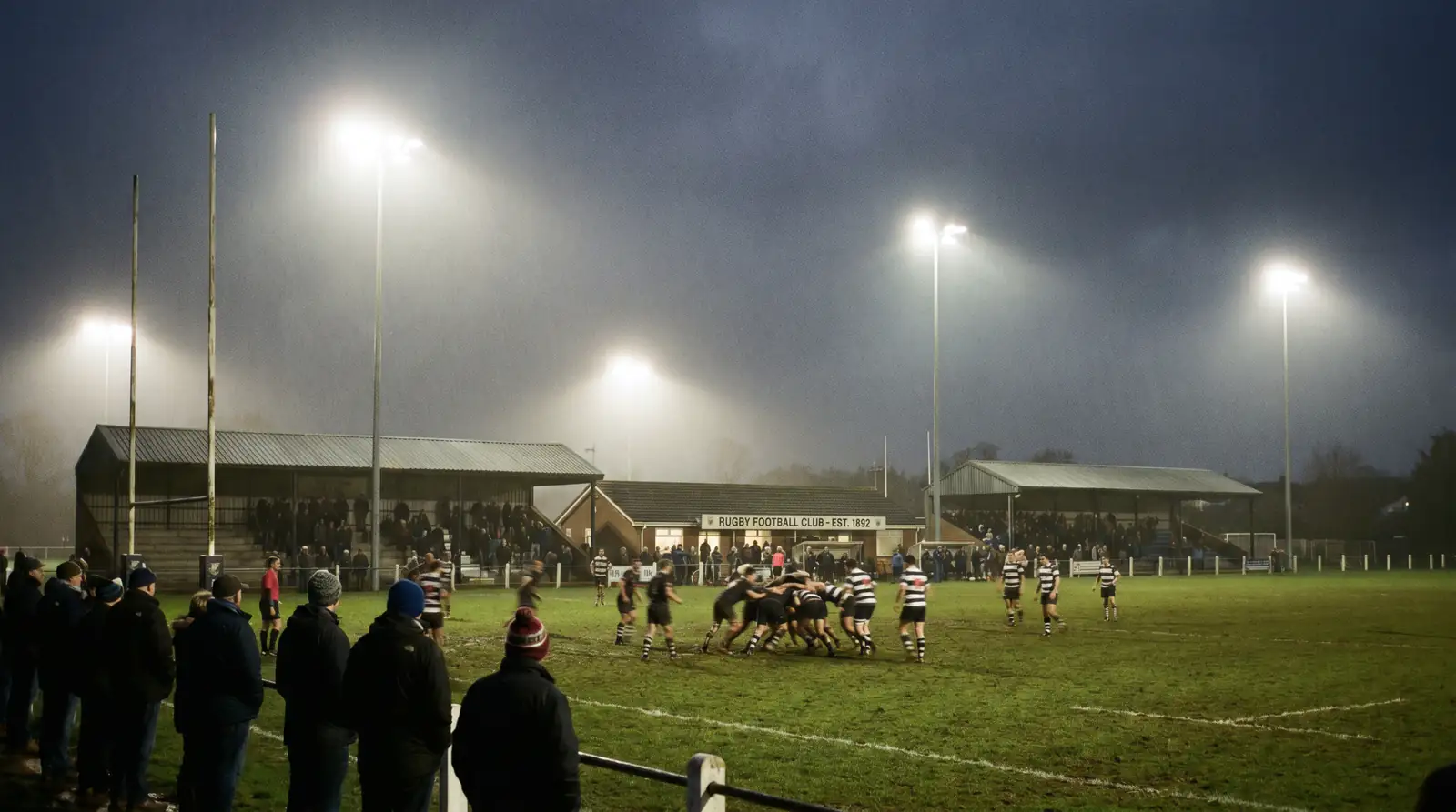 Premiership rugby match under floodlights at an English club ground
