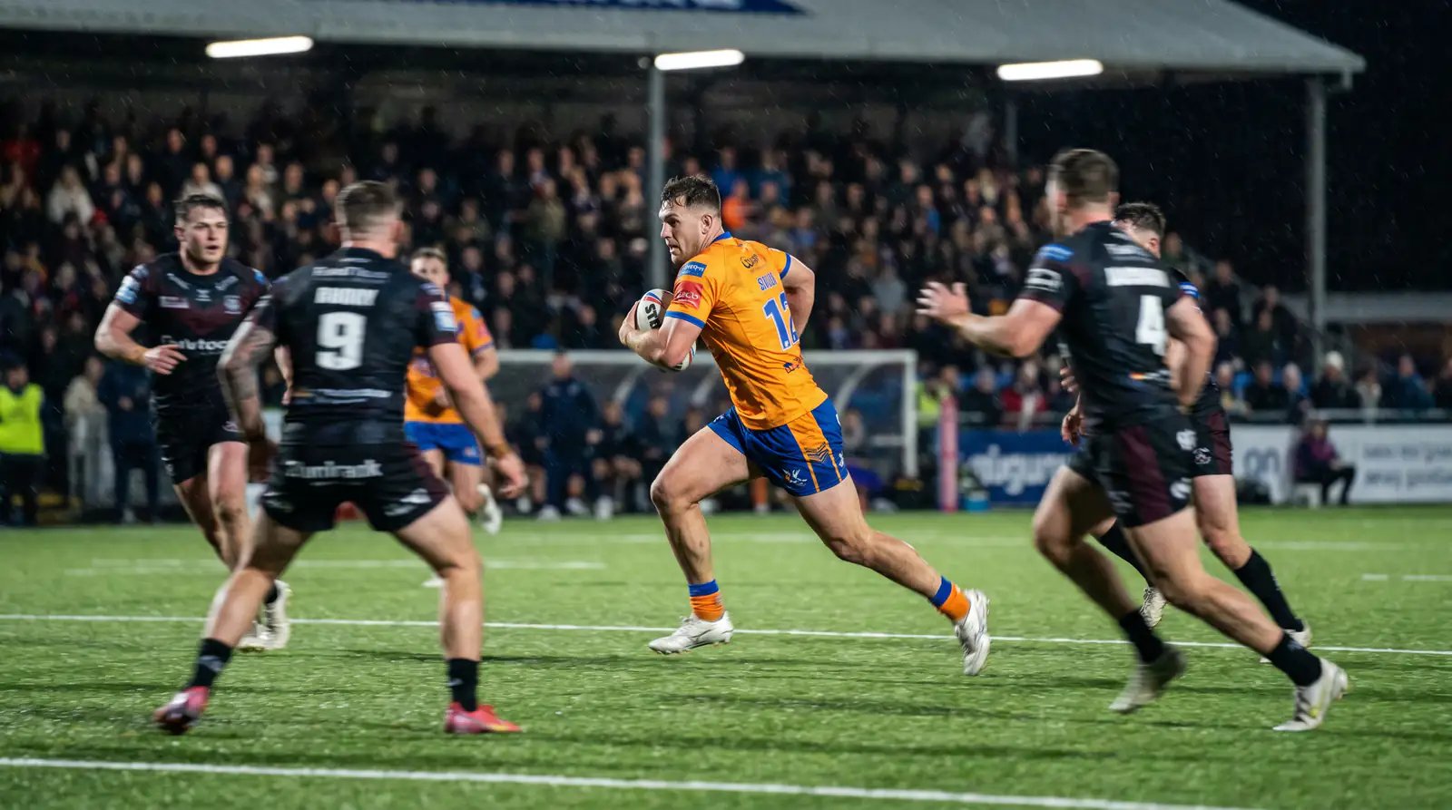 Fast-paced rugby league match showing quick ball movement and open play