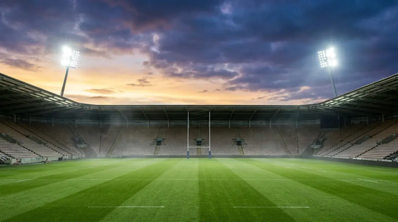 Rugby pitch under floodlights with goalposts and match-day atmosphere
