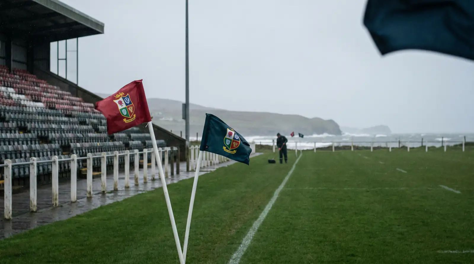 Corner flags blowing in strong wind at an exposed rugby stadium